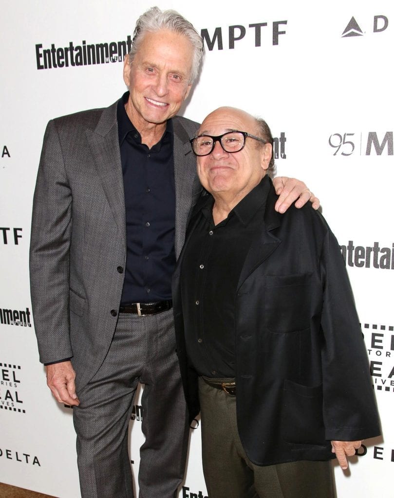 Danny Devito in black suit posing for camera with his friend - Hollywood short actors