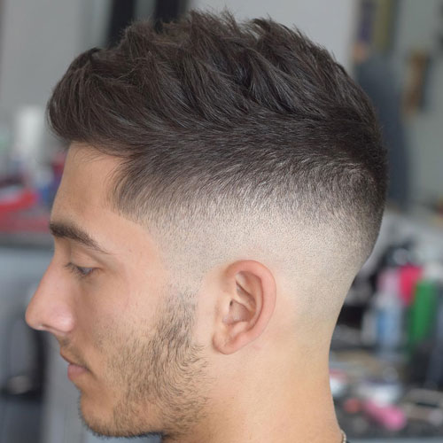A man is showing the side view of his Textured Mid Skin Fade - Popular Haircut For Men in 2022