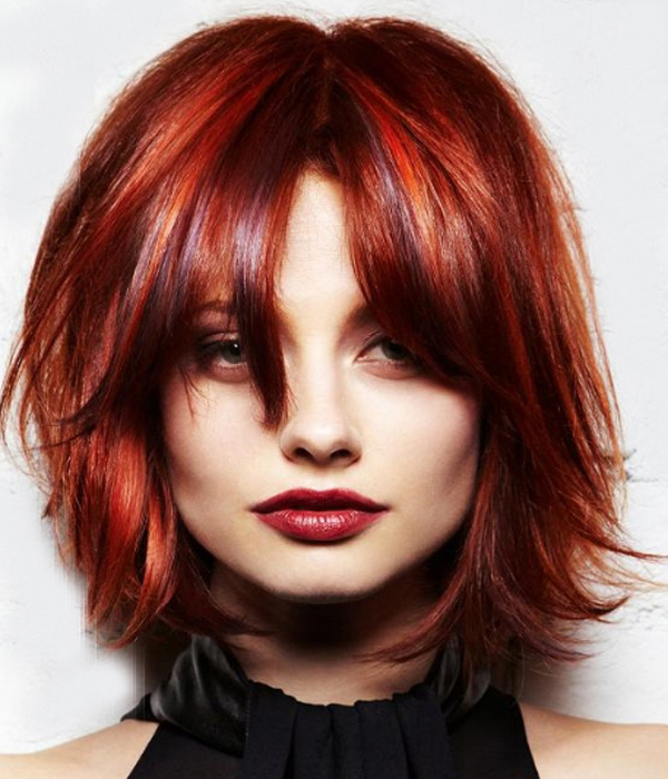 A girl in black deep cut top with red lipstick showing her short Red Bob Hairstyle - hair color benefits