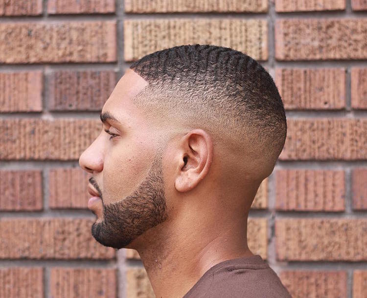 A man in grey t-shirt showing the side view of his Waves with Skin Fade - Latest Hair Cut for Men and Boys