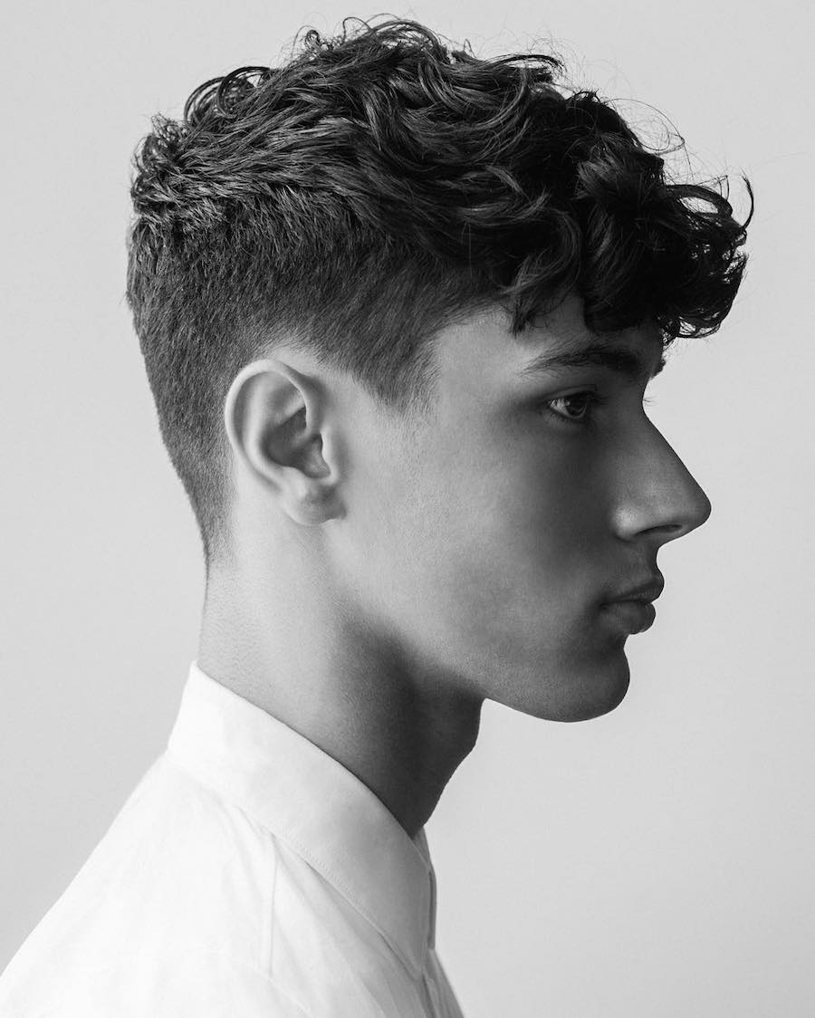 A boy in white shirt showing the side view of his Long Curly Fringe with Short Sides - long hairstyles for boys