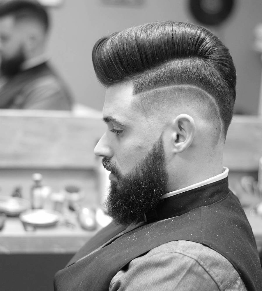 A man in black shirt showing the side view of his High-low Fade Pomp - Latest Hair Cut for Men and Boys