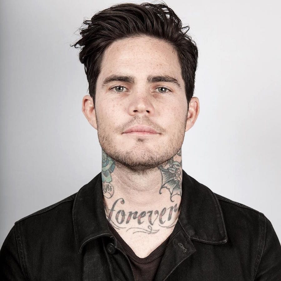A man in black shirt and tattoos on his neck showing his Wavy Medium Length Hairstyle - Latest Hair Cut for Men and Boys