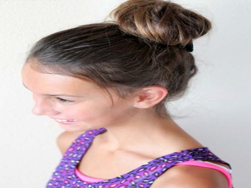 A girl in blue and pink cut sleeves top showing her high bun - hairstyles for girls braids