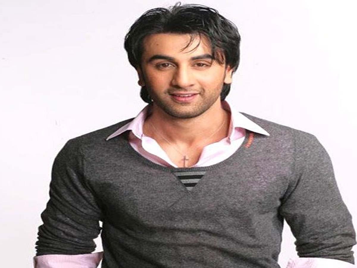 Ranbir Kapoor in gray sweater with white shirt smiling and posing for the camera - bollywood hairstyle actor