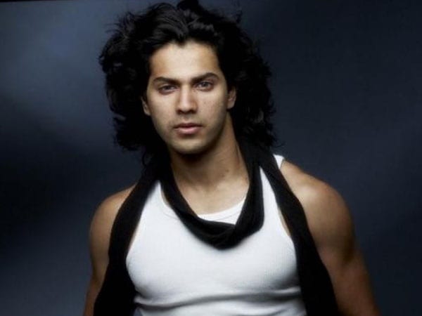 Varun Dhawan in white vest with black scarf posing for camera and showing his Long Hairs - Varun Dhawan hairstyles