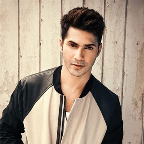 Varun Dhawan in black and off white jacket posing for camera and showing his schoolboy look - Varun Dhawan Hairstyles