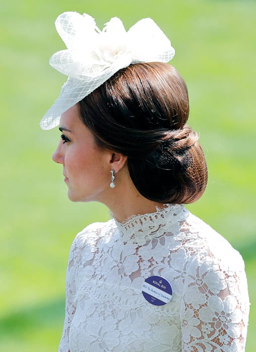 Catherine, Duchess of Cambridge poses in white dress and hair bun