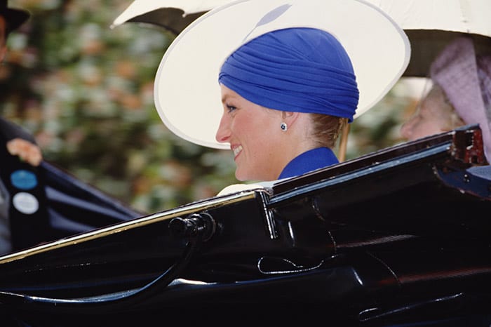 Princess Diana wears blue dress, sitting in a black car 