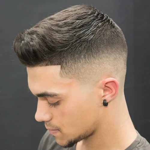 A man in grey round neck t-shirt along with black earring showing the side view of his Bald Fade Hairstyle A man in grey round neck t-shirt along with black earring showing the side view of his Bald Fade Hairstyle - latest hairstyle for Men 2022