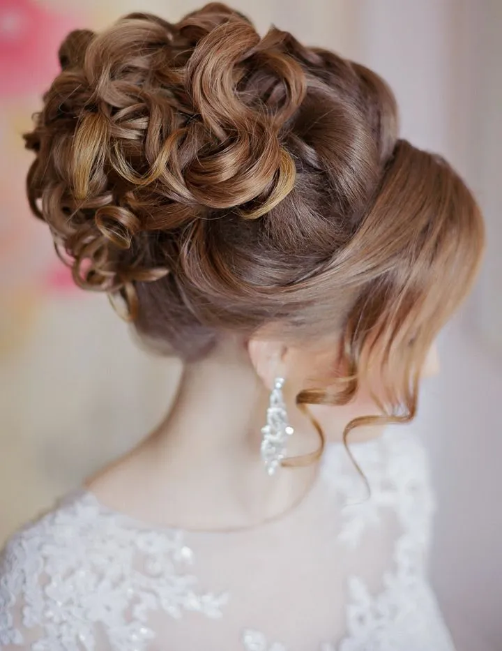 A girl in white net dress with danglers showing the side view of her High Curls hairstyle A girl in white net dress with danglers showing the side view of her High Curls hairstyle - hairstyles for Indian Wedding