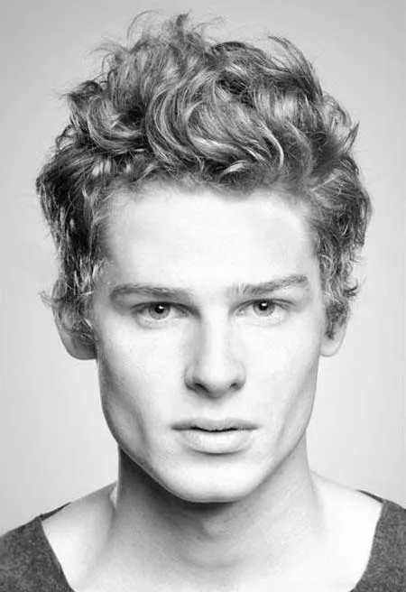 A man in grey t-shirt showing his Messy Curls Hairstyle A man in grey t-shirt showing his Messy Curls Hairstyle - trendy hairstyles for Men 2022
