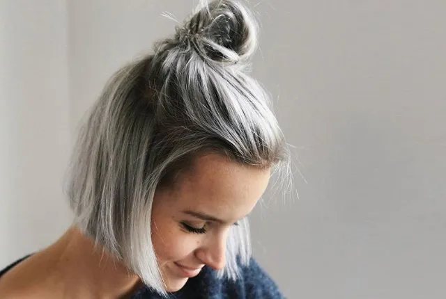 A smiling woman in blue sweater and Spring Knot hairstyle A smiling woman in blue sweater and Spring Knot hairstyle - hairstyles for girls with medium hair