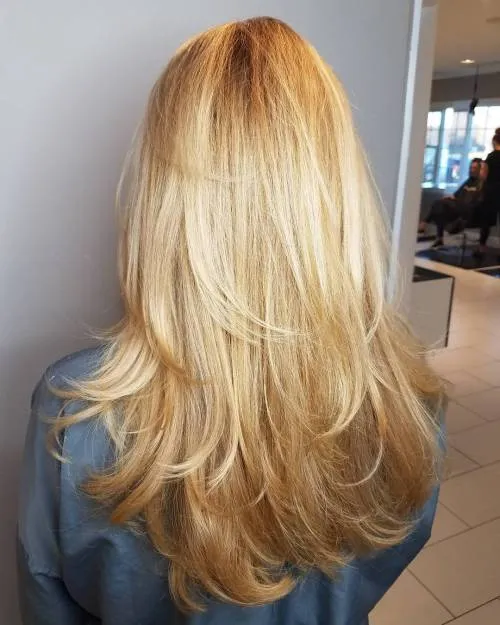 Woman in blue denim shirt showing the back view of her U-Shaped Long Feathered Layers hairstyle Woman in blue denim shirt showing the back view of her U-Shaped Long Feathered Layers hairstyle - best haircut for long hair female