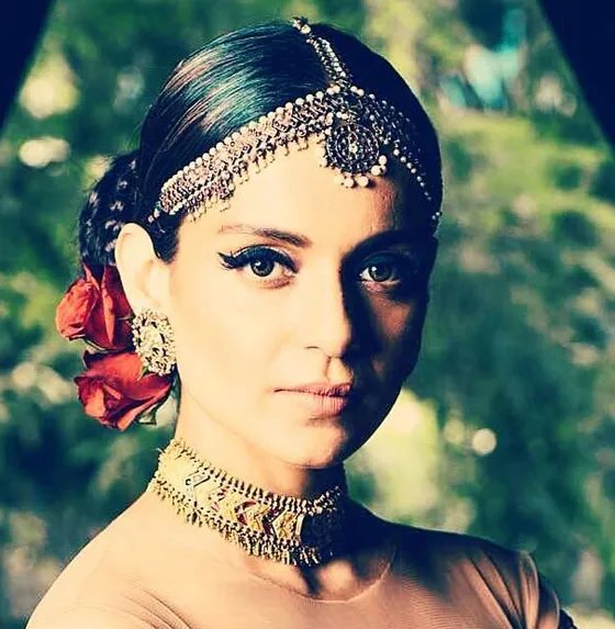 A girl in peach color blouse and heavy jewellery showing her senorita bun A girl in peach color blouse and heavy jewellery showing her senorita bun - bun hairstyles for Indian wedding