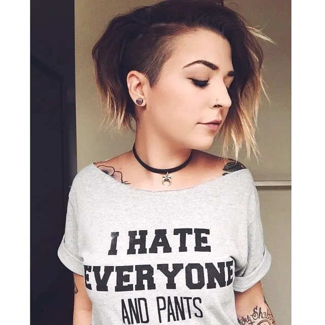 A girl in grey top with lots of tattoos showing her Bob with shaved side A girl in grey top with lots of tattoos showing her Bob with shaved side - haircut Teenage Girls