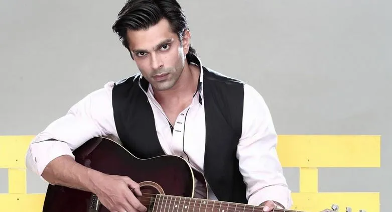 Karan Singh Grover in blue half jacket and white shirt playing guitar Karan Singh Grover in blue half jacket and white shirt playing guitar - Most Handsome Indian TV Actors