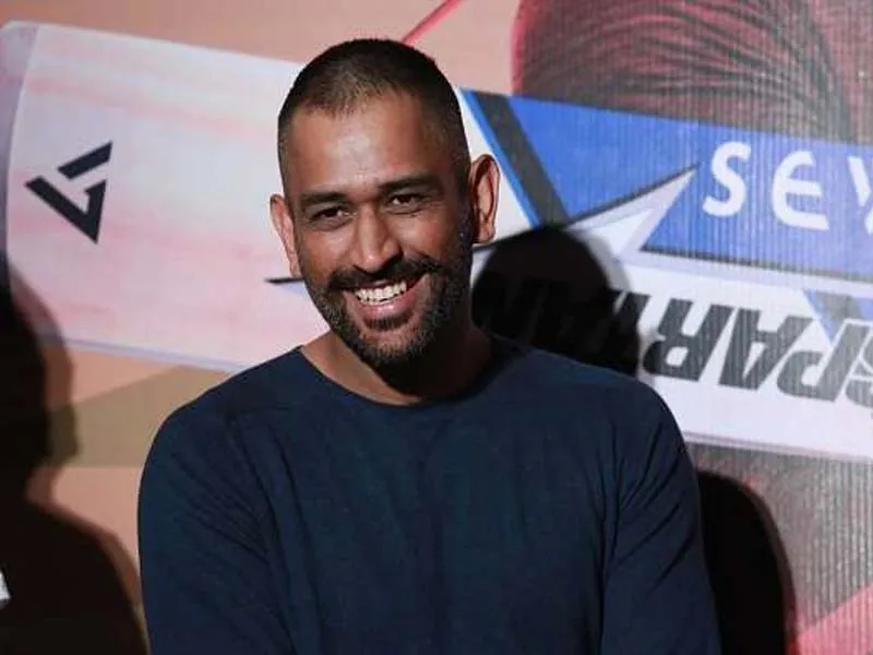 Smiling MS Dhoni in blue round neck t-short posing for camera - Hairstyles of MS Dhoni