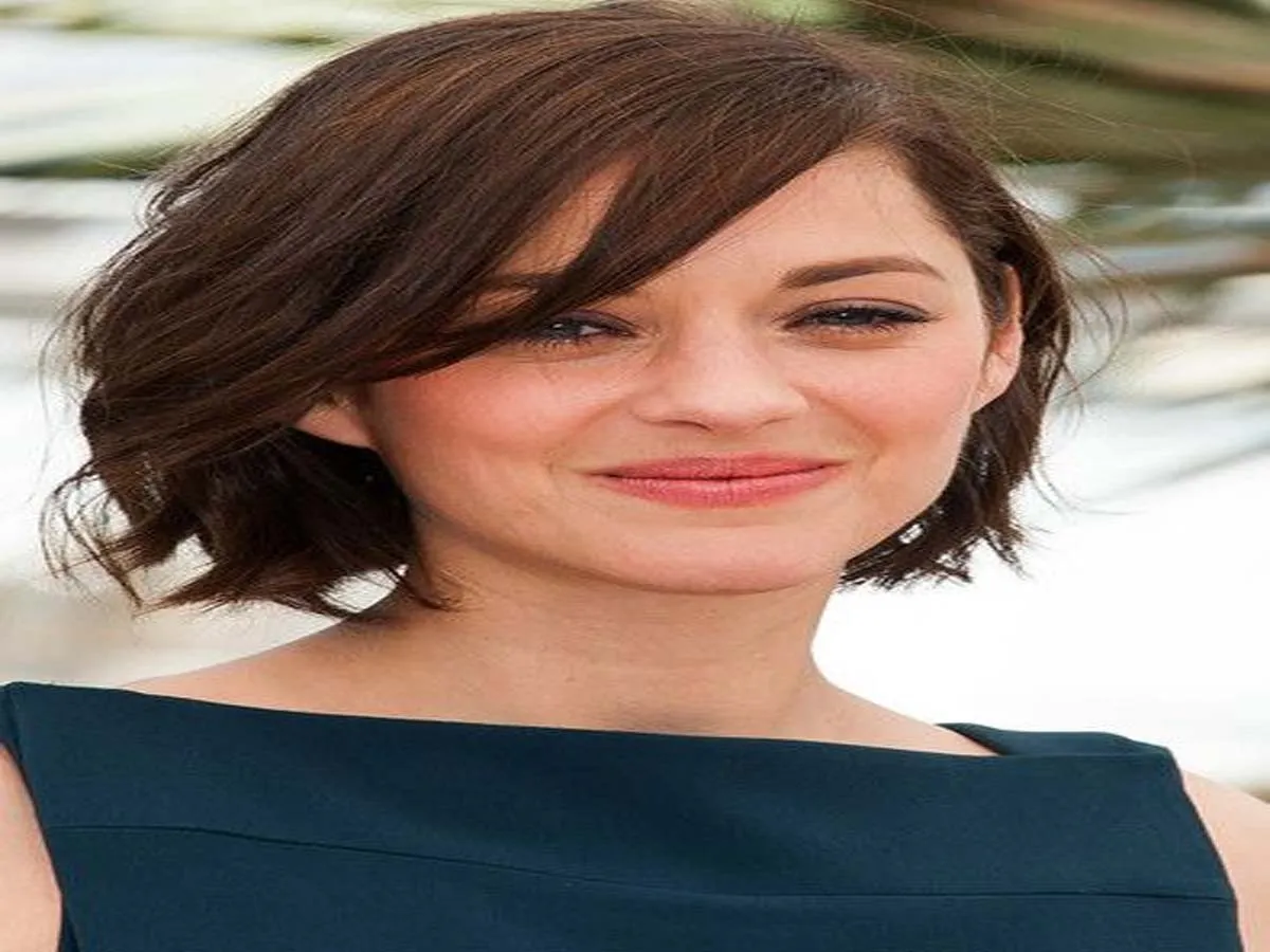 Smiling Marion Cottilard in boat neck blue dress posing for camera - short hair hollywood celebrities