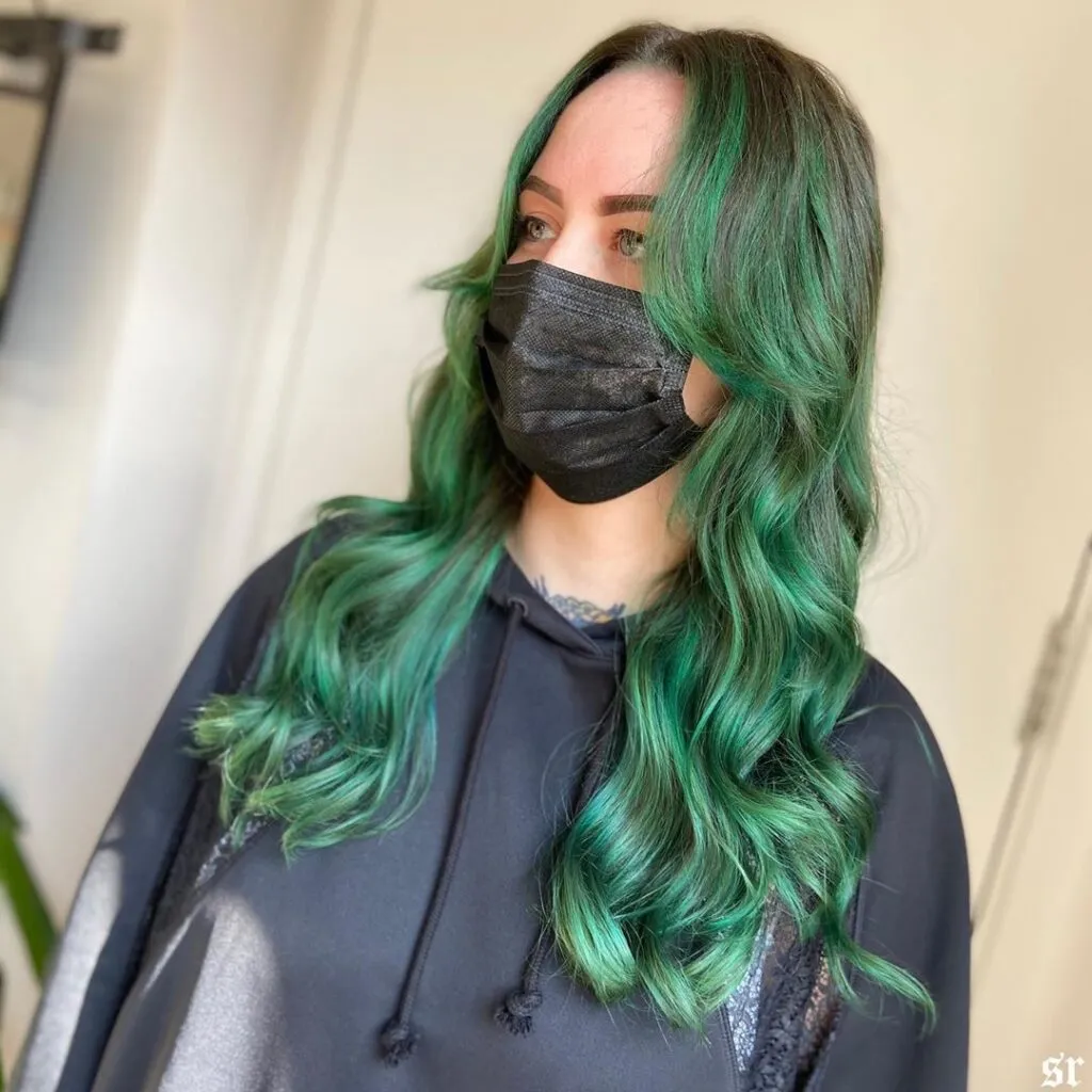 A girl in black hood with mask showing Forest Green Hair color with side pose A girl in black hood with mask showing Forest Green Hair color with side pose - green hair color ideas