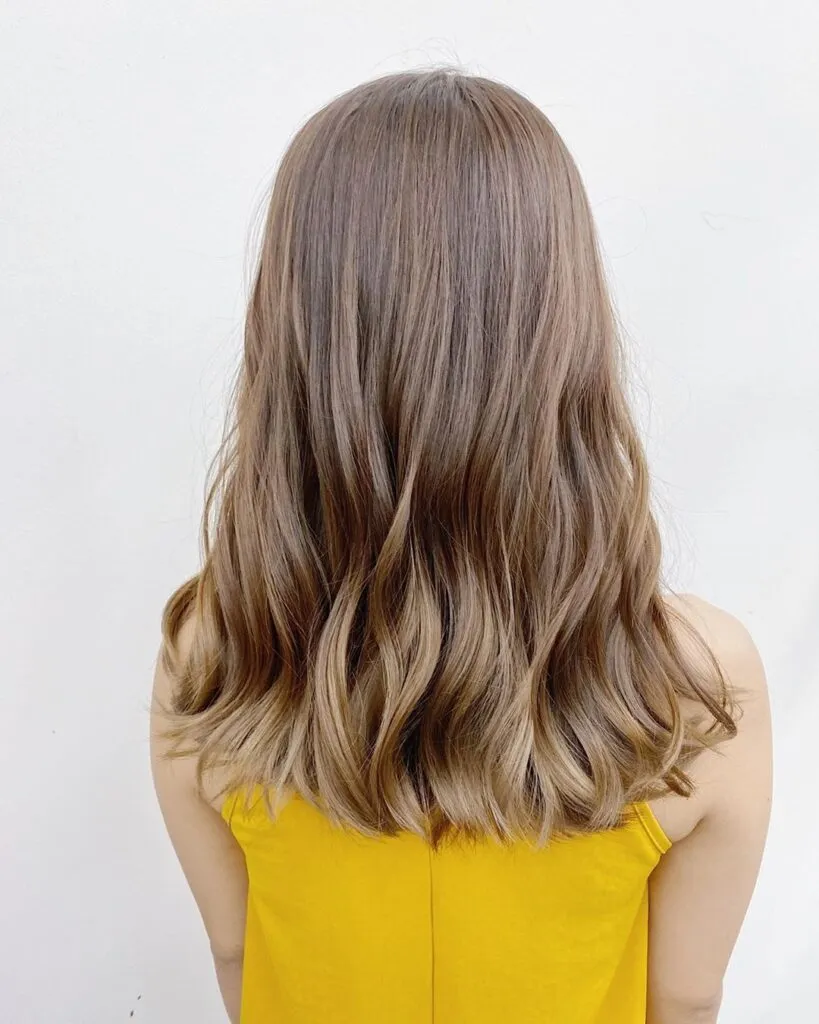 Girl in yellow top showing Medium Champagne Hair color with Back pose Girl in yellow top showing Medium Champagne Hair color with Back pose - light blonde hair color 2022