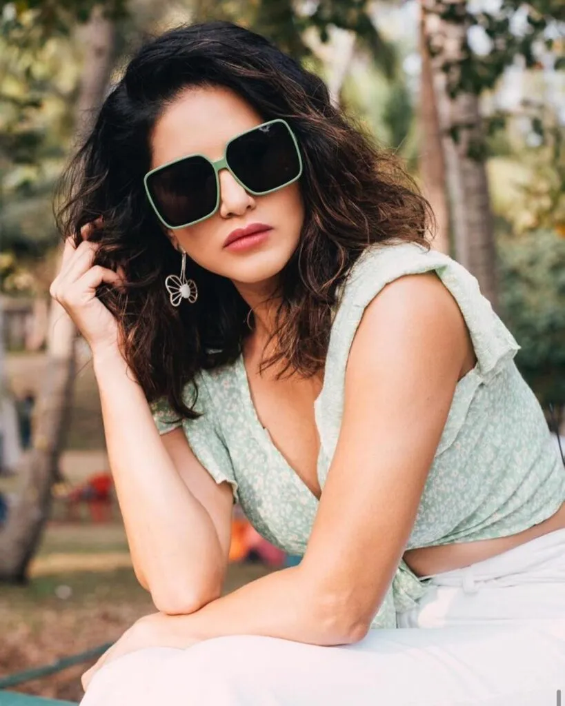 Sunny Leone in off-white cop top and goggles showing her Messy Curls - Sunny Leone best Hairstyles