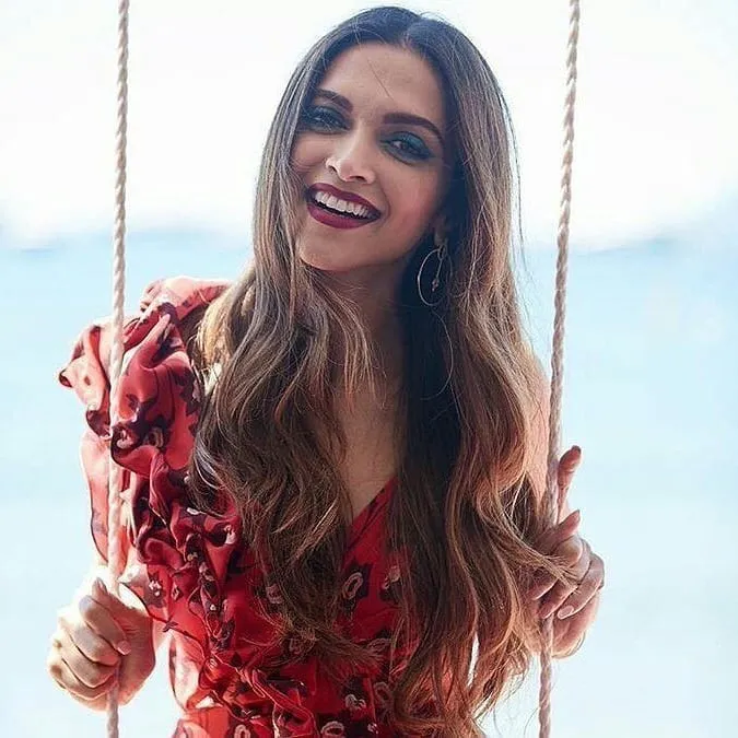 Deepika Padukone in red floral dress showing her Stunning curls for parties  Deepika Padukone in red floral dress showing her Stunning curls for parties - Deepika padukone bun hairstyles