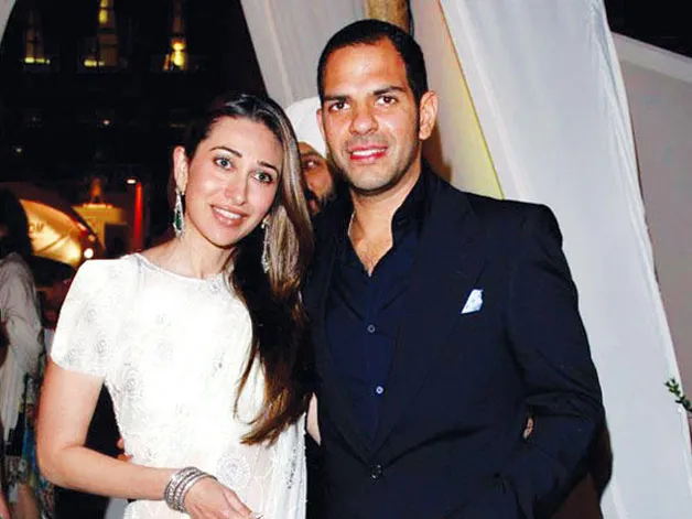 Karishma Kapoor in white saree and Sanjay Kapur in blue suit smiling Karishma Kapoor in white saree and Sanjay Kapur in blue suit smiling - famous celebrity divorce list