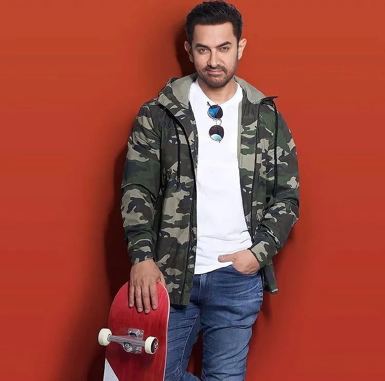 Aamir Khan in army print jacket and white shirt holding a skate board Aamir Khan in army print jacket and white shirt holding a skate board - most handsome man in India