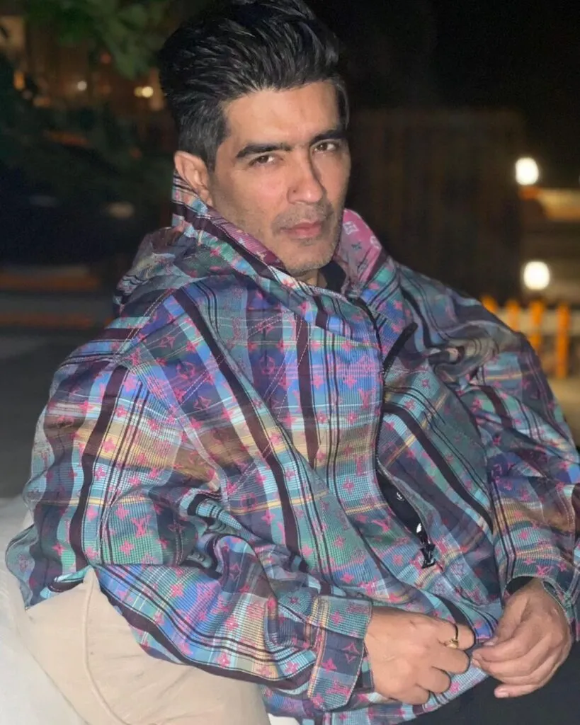 Manish Malhotra in multicolor jacket sitting and posing for camera Manish Malhotra in multicolor jacket sitting and posing for camera - gay and lesbian celebrities India