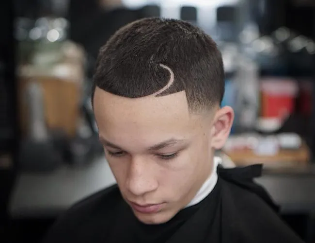 A boy is sitting and showing his Curved Part + Line Up + High Taper Fade A boy is sitting and showing his Curved Part + Line Up + High Taper Fade - hairstyles for boys 2021