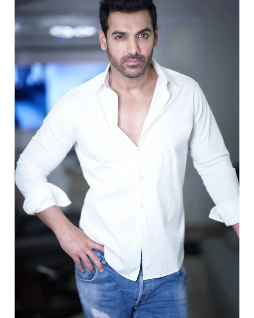 John Abraham posing for camera in white shirt John Abraham posing for camera in white shirt - most popular actor in bollywood