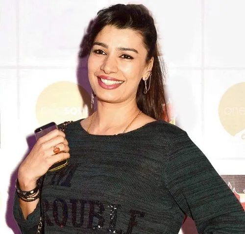 Smiling Mink Brar posing for camera in grey top Smiling Mink Brar posing for camera in grey top - lesbian fashion designers