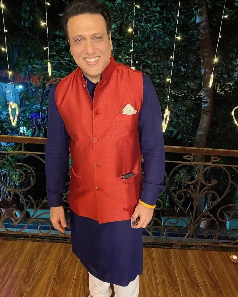 Govinda in Blue Kurta and red half jacket posing for Camera Govinda in Blue Kurta and red half jacket posing for Camera - bollywood short actors