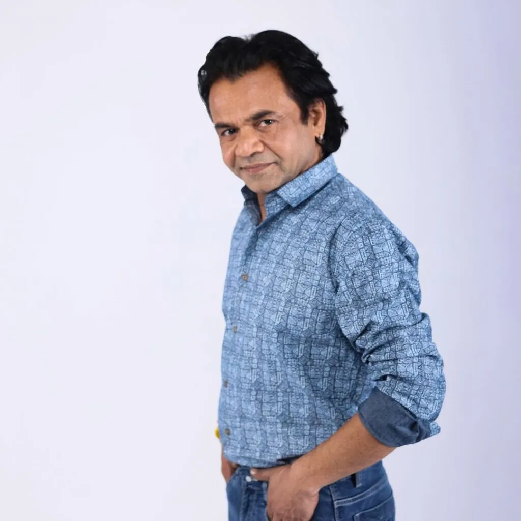 Rajpal Yadav in blue printed shirt posing for camera Rajpal Yadav in blue printed shirt posing for camera - Bollywood short actors
