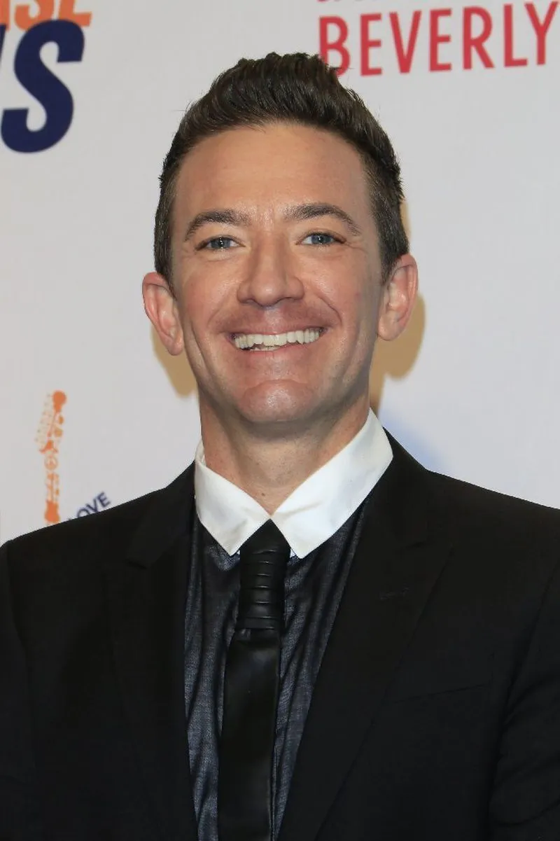 Smiling David Faustino in black suit posing for camera Smiling David Faustino in black suit posing for camera - Short Male Actors