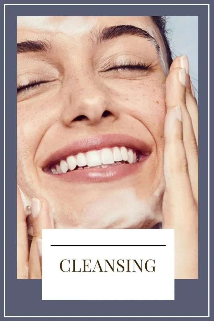 A smiling girl is cleansing her face A smiling girl is cleansing her face - daily skin care routine