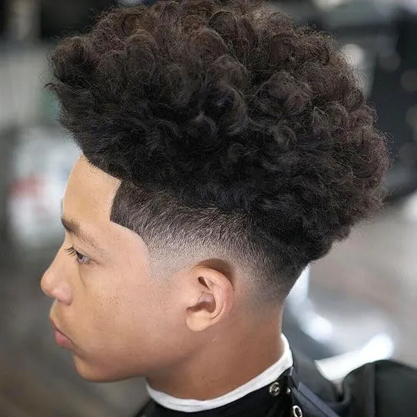 A boy showing his extreme curly hair with blowout with taper fade hairstyle A boy showing his extreme curly hair with blowout with taper fade hairstyle - short hairstyle for boys
