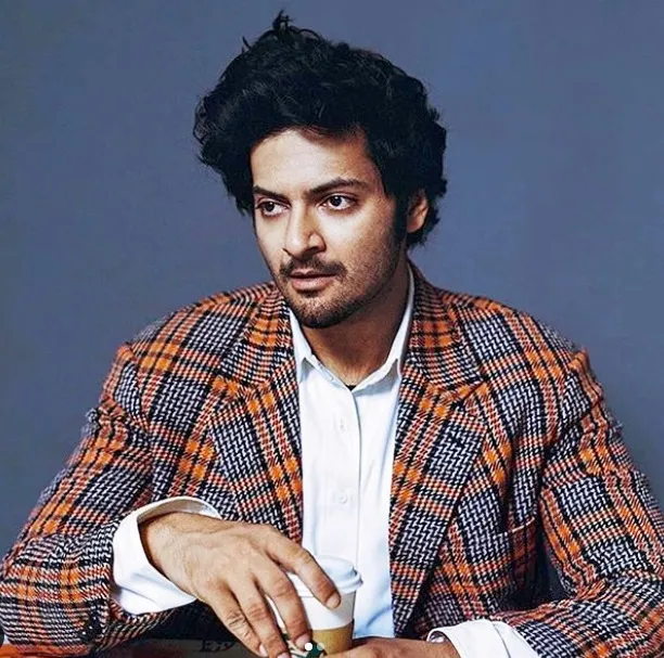 Ali Fazal in multi color coat with white shirt posing for camera and showing his side-swept retro hair look Ali Fazal in multi color coat with white shirt posing for camera and showing his side-swept retro hair look - bollywood actors hairstyles