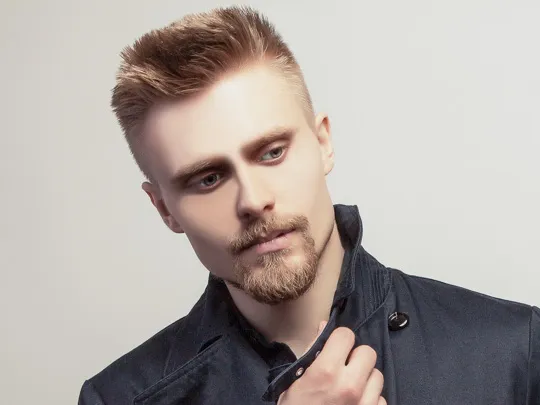 A man in black jacket and french cut beard showing his Simple Texture with Low Volume hairstyle A man in black jacket and french cut beard showing his Simple Texture with Low Volume hairstyle - men's hairstyle