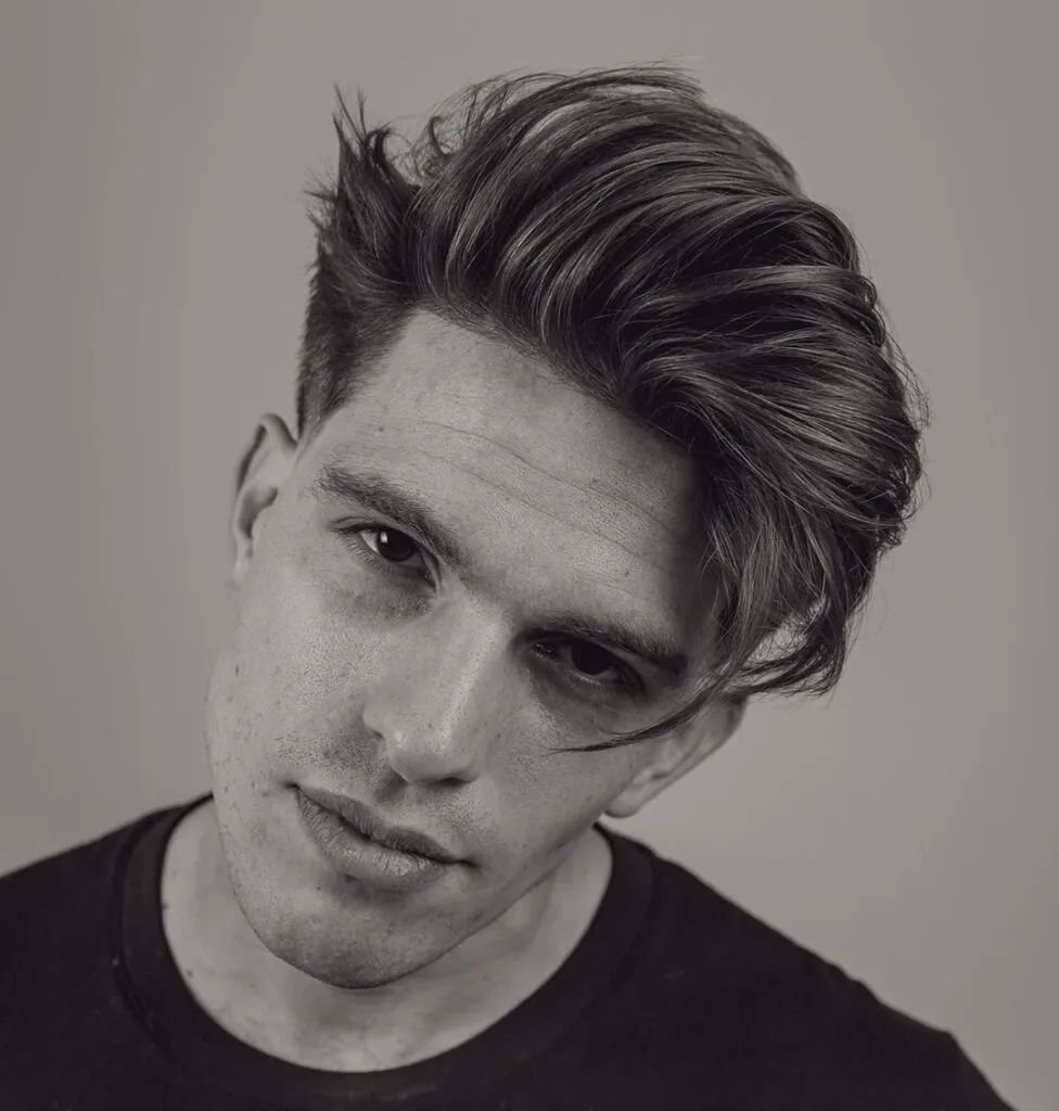 A man in black round neck t-shirt showing his Haircut With Long Fringe A man in black round neck t-shirt showing his Haircut With Long Fringe - latest hairstyle for men