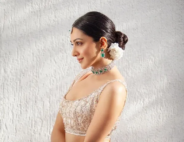 A girl in silver embraided blouse with a necklace showing the side view of her Sleek Tight Bun A girl in silver embraided blouse with a necklace showing the side view of her Sleek Tight Bun - Bridal hairstyles