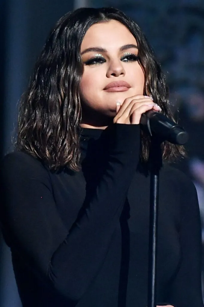 Selena Gomez in black high neck dress posing for camera and showing her Wet Waves Selena Gomez in black high neck dress posing for camera and showing her Wet Waves - selena gomez age