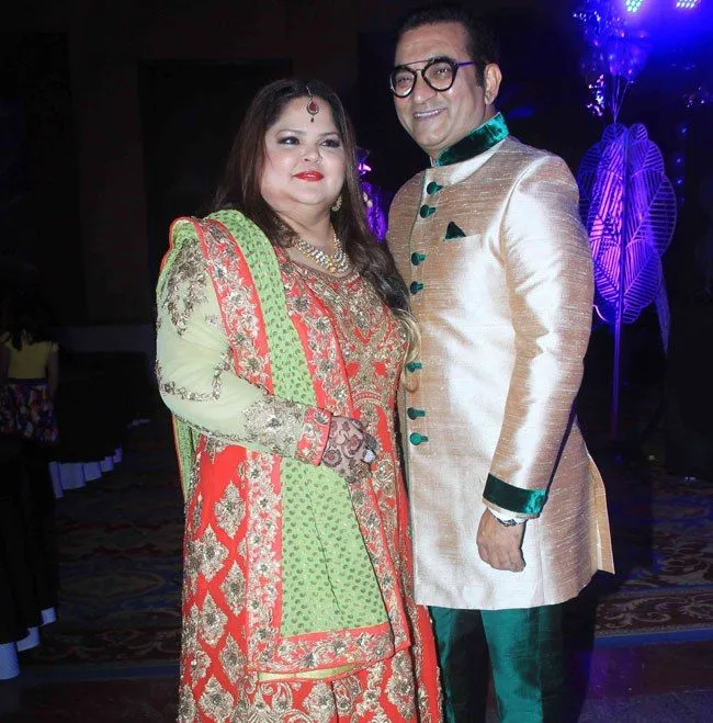Abhijeet Bhattacharya in golden and blue sherwani with wife Sumati in orange and off white traditional dress Abhijeet Bhattacharya in golden and blue sherwani with wife Sumati in orange and off white traditional dress - Indian singers with partners