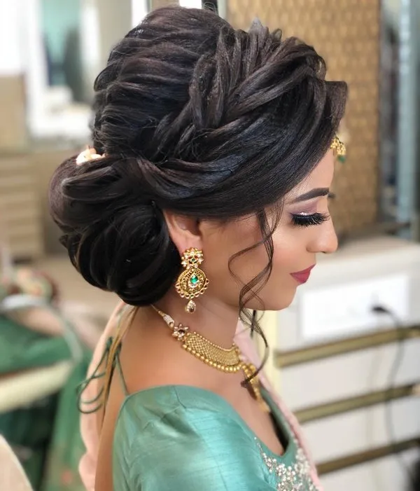 A girl in light green blouse and golden jewellery posing for camera and showing the side view of her Twisted Braided Bun A girl in light green blouse and golden jewellery posing for camera and showing the side view of her Twisted Braided Bun - bridal hairstyles