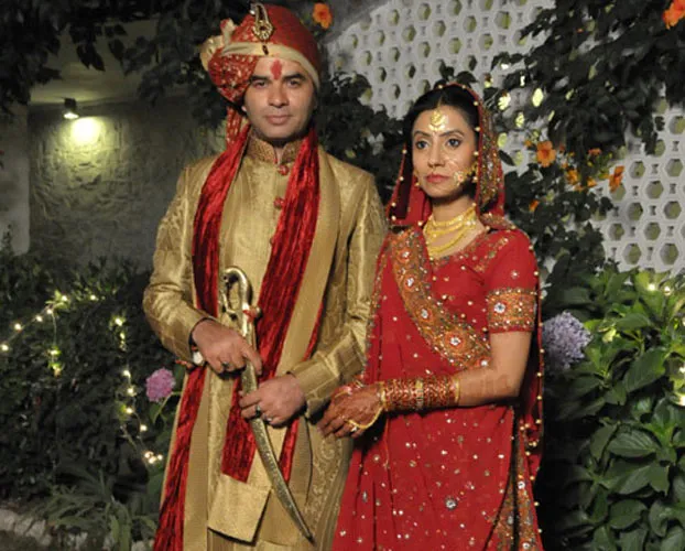 Mohit Chauhan in traditional groom outfit with his wife Prathna Gehlot in red lehenga Mohit Chauhan in traditional groom outfit with his wife Prathna Gehlot in red lehenga - famous couple singers India