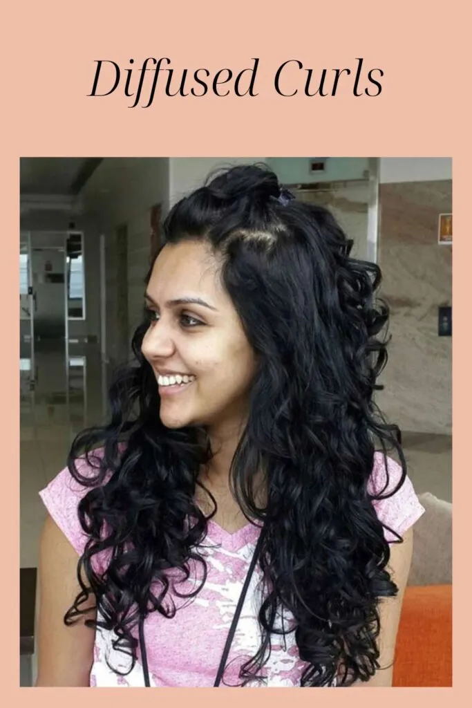 A smiling girl in pink t-shirt showing the side view of her diffused curls hairstyle A smiling girl in pink t-shirt showing the side view of her diffused curls hairstyle - hairstyles for Indian Women