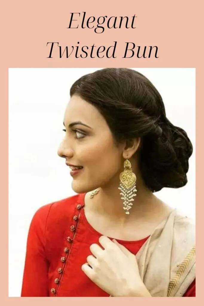 A girl in red kurta white dupatta with big earrings showing the side view of her Elegant Twisted Bun A girl in red kurta white dupatta with big earrings showing the side view of her Elegant Twisted Bun - Indian women hairstyles