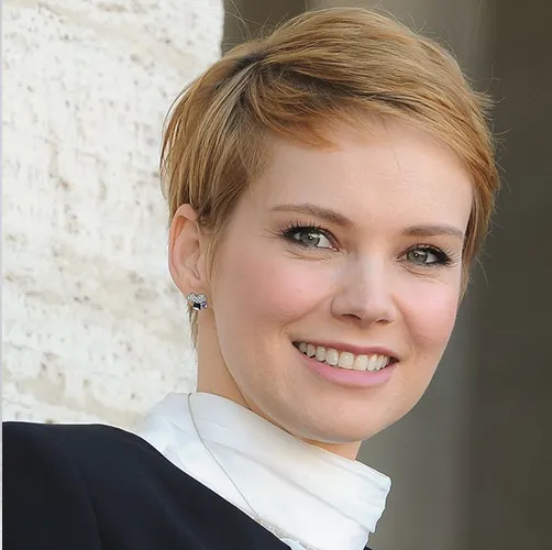 A women in black and white high neck dress posing for camera and showing her pixie hair cut - Best American hairstyles