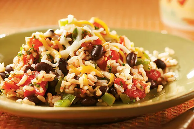 Spicy Beans and Rice served in green plate with cheese on it - vegetarian bodybuilding diet plan